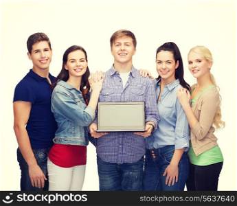 education, advertisement and new technology concept - smiling students with laptop computer blank screen