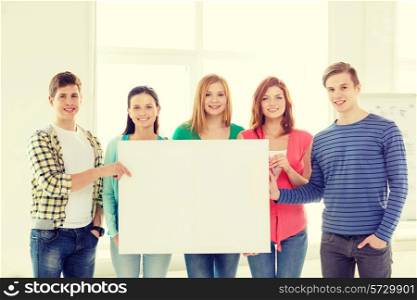 education, advertisement and school concept - group of smiling students at school holding white blank board