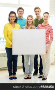 education, advertising and school concept - five smiling students with white blank board at school
