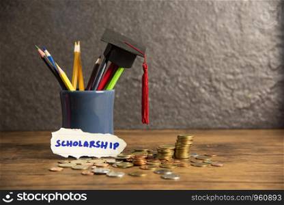 Education and back to school concept with graduation cap on pencils colour in a pencil case on dark background / scholarships with money coin wooden table