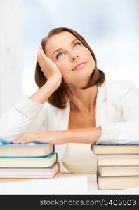 education and business concept - bored young woman with many books indoors