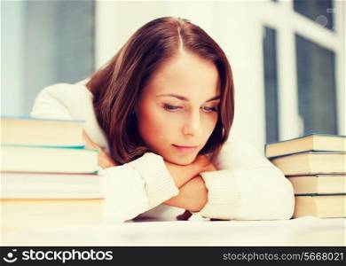 education and business concept - bored young woman with many books indoors