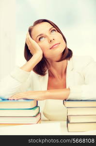 education and business concept - bored young woman with many books indoors