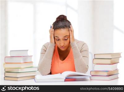 education and business concept - tired student with pile of books and notes studying indoors