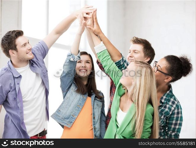 education and friendship concept - happy students giving high five at school