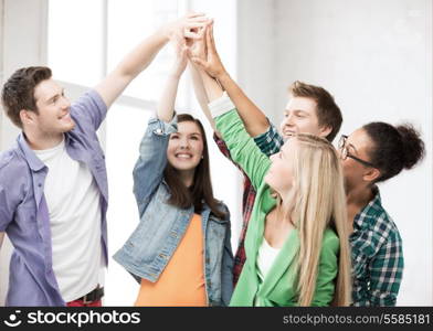 education and friendship concept - happy students giving high five at school