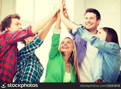 education and friendship concept - happy students giving high five at school