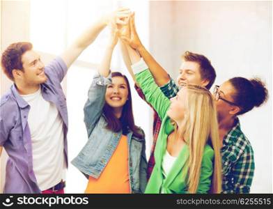 education and friendship concept - happy students giving high five at school. happy students giving high five at school