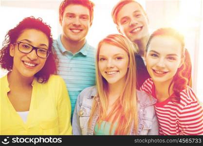 education and happiness concept - group of young smiling people at home or school. group of smiling people at school or home