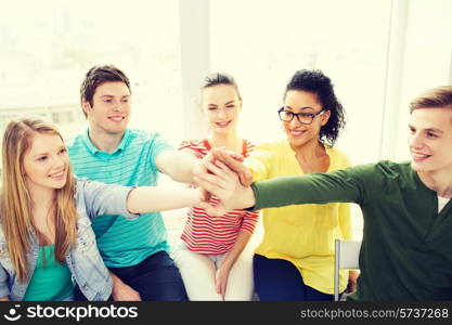 education and happiness concept - smiling students at school making high five gesture