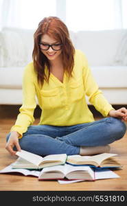 education and home concept - smiling student girl in eyeglasses reading books at home