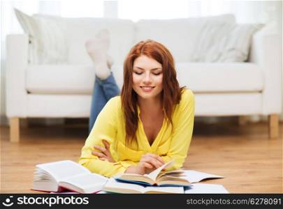 education and home concept - smiling student girl reading books at home