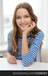 education and home concept - smiling teenage girl with notebook at home