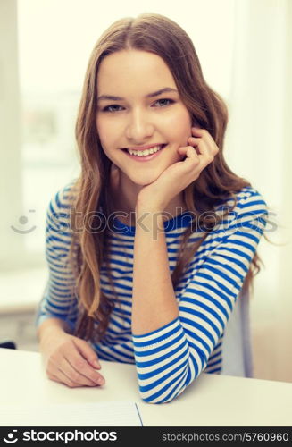 education and home concept - smiling teenage girl with notebook at home