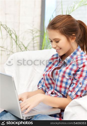 education and internet concept - smiling student girl with laptop at home