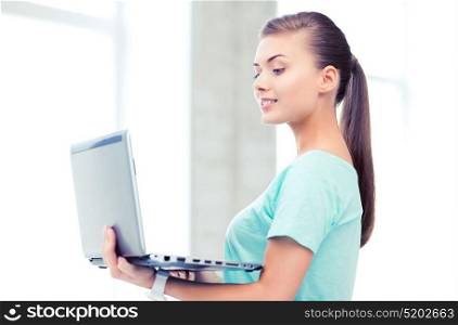 education and internet concept - smiling student girl with laptop at school. smiling student girl with laptop at school