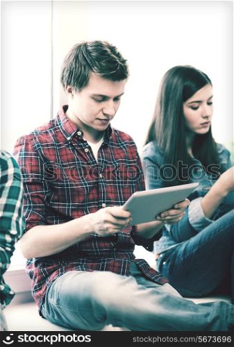 education and internet concept - student looking into tablet pc at school