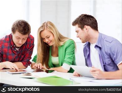 education and internet - smiling students browsing in tablet pc