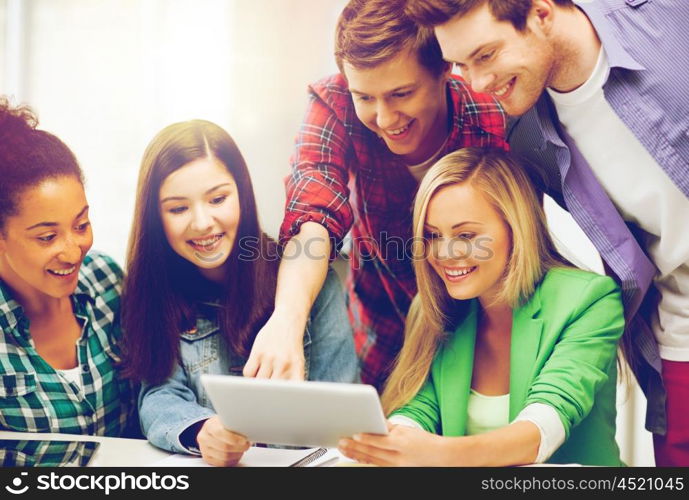 education and internet - smiling students looking at tablet pc in lecture at school. students looking at tablet pc in lecture at school