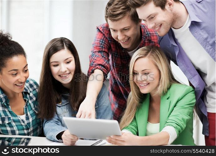 education and internet - smiling students looking at tablet pc in lecture at school
