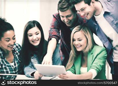 education and internet - smiling students looking at tablet pc in lecture at school