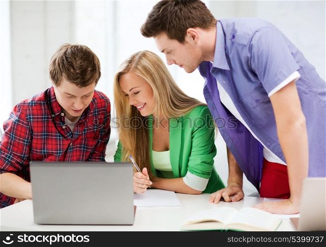 education and internet - smiling students writing test or exam in lecture at school