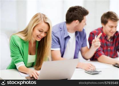 education and internet - smiling students writing test or exam in lecture at school