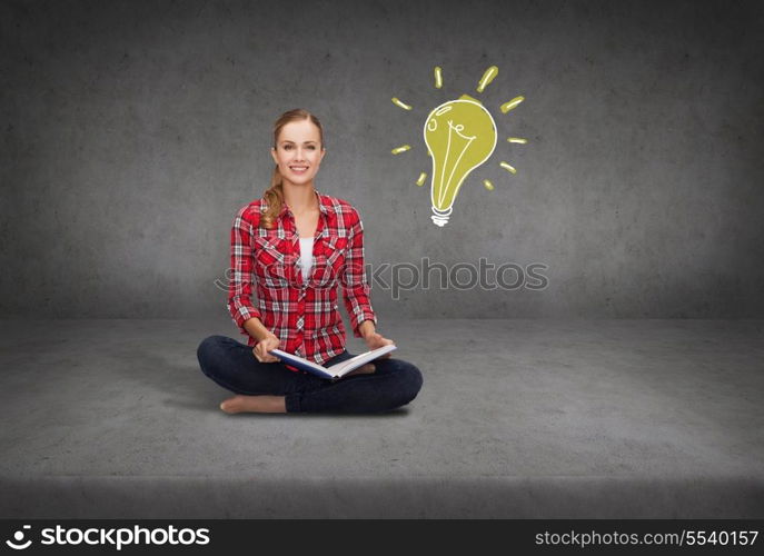 education and leisure concept - smiling young woman sitting on floor with book