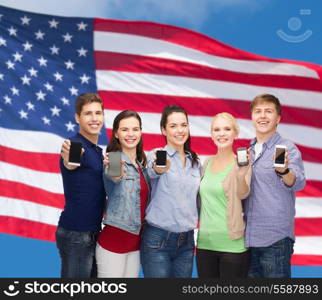 education and modern technology concept - smiling students showing blank smartphones screens