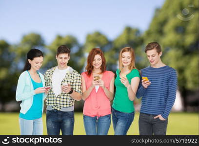 education and modern technology concept - smiling students with smartphones