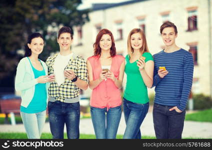 education and modern technology concept - smiling students with smartphones