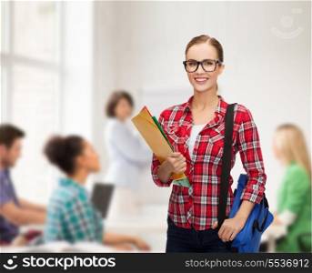education and people concept - female student in eyeglasses with bag and folders