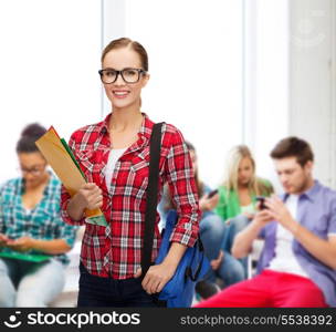 education and people concept - female student in eyeglasses with bag and folders