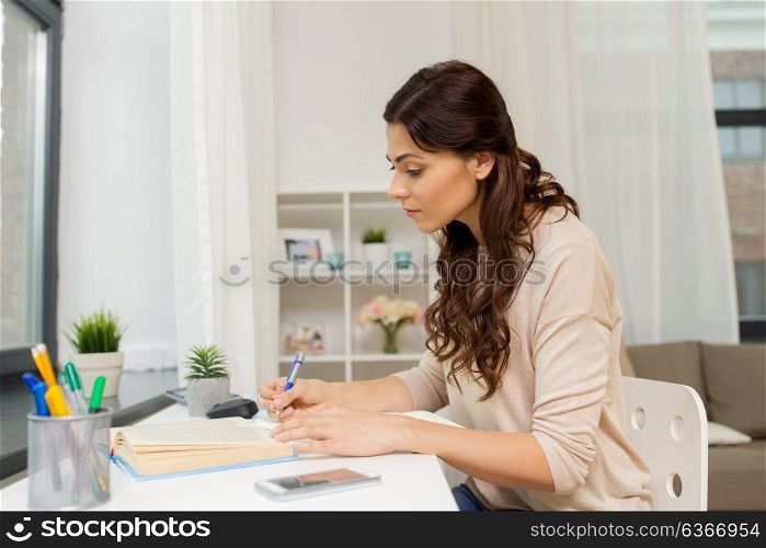education and people concept - female student with book learning at home. female student with book learning at home