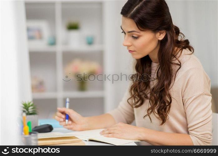 education and people concept - female student with book learning at home. female student with book learning at home. female student with book learning at home