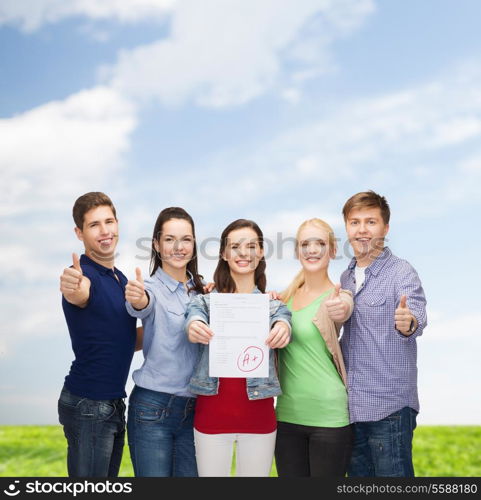 education and people concept - group of smiling students standing and showing test and thumbs up