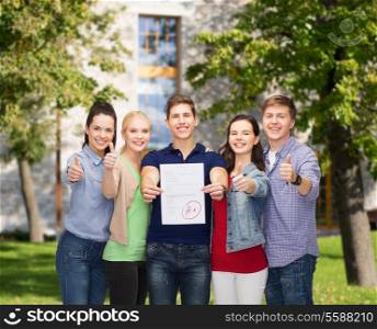 education and people concept - group of smiling students standing and showing test and thumbs up