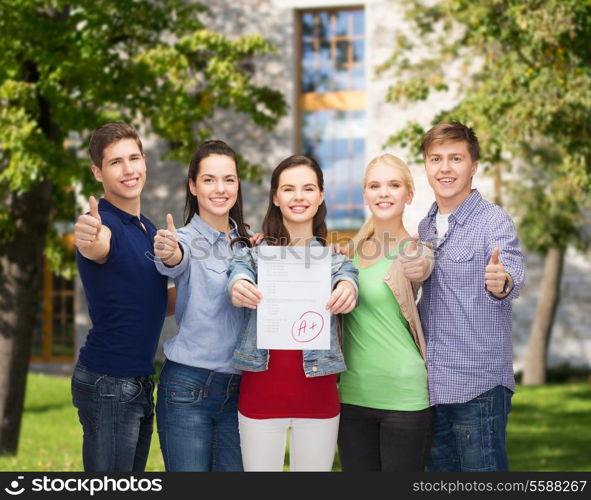 education and people concept - group of smiling students standing and showing test and thumbs up