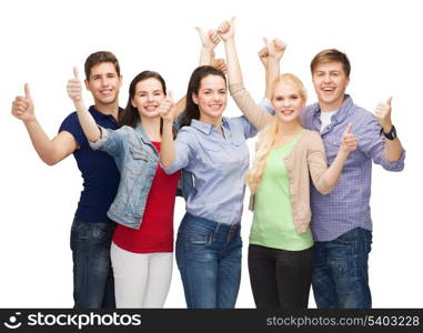 education and people concept - group of smiling students standing and showing thumbs up