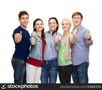 education and people concept - group of smiling students standing and showing thumbs up