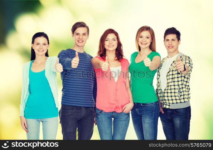 education and people concept - group of smiling students standing and showing thumbs up