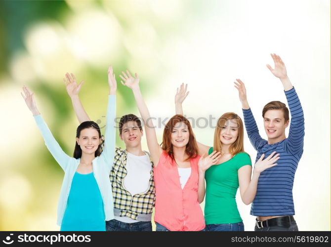 education and people concept - group of smiling students standing and waving hands