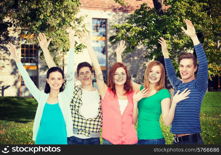 education and people concept - group of smiling students standing and waving hands