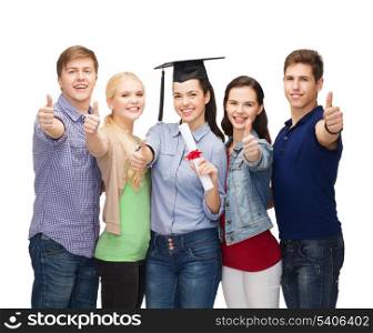 education and people concept - group of standing smiling students with diploma and corner-cap showing thumbs up