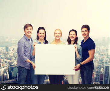 education and people concept - group of standing smiling students with white blank board