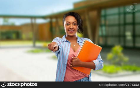 education and people concept - happy african american young student woman with notebooks over school background. african american student woman with notebooks