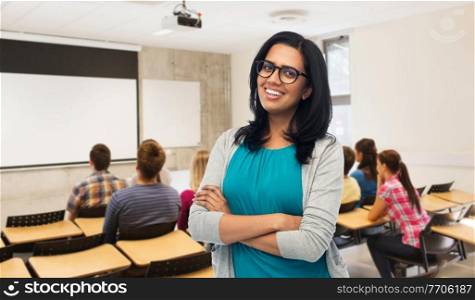 education and people concept - happy smiling young indian woman in glasses over classroom at high school on background. happy smiling young indian woman in glasses