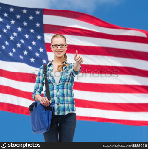 education and people concept - smiling female student in eyeglasses with laptop bag showing thumbs up