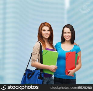 education and people concept - two smiling students with bag and folders standing