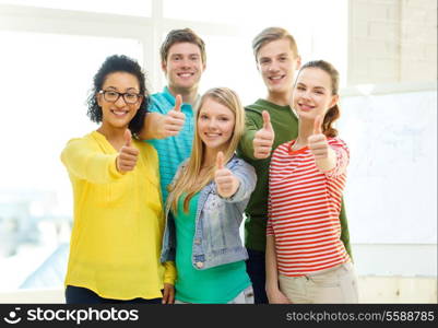 education and school concept - five smiling showing thumbs up at school